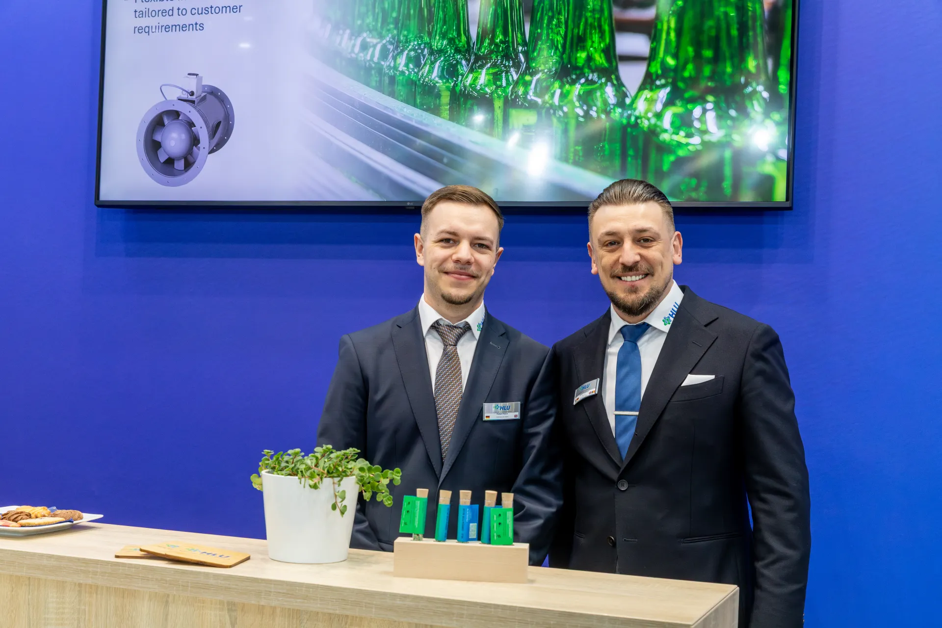 HLU staff at the counter below an axial fan presentation at MCE 2026