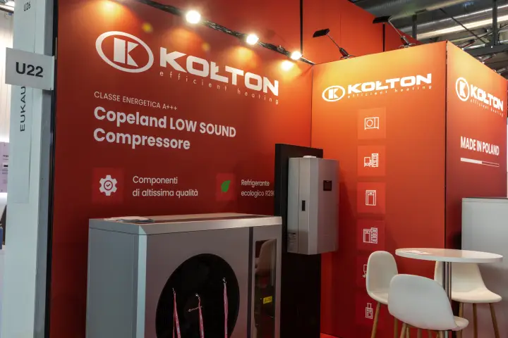 Kołton heat pump outdoor unit against a red wall promoting a Copeland compressor