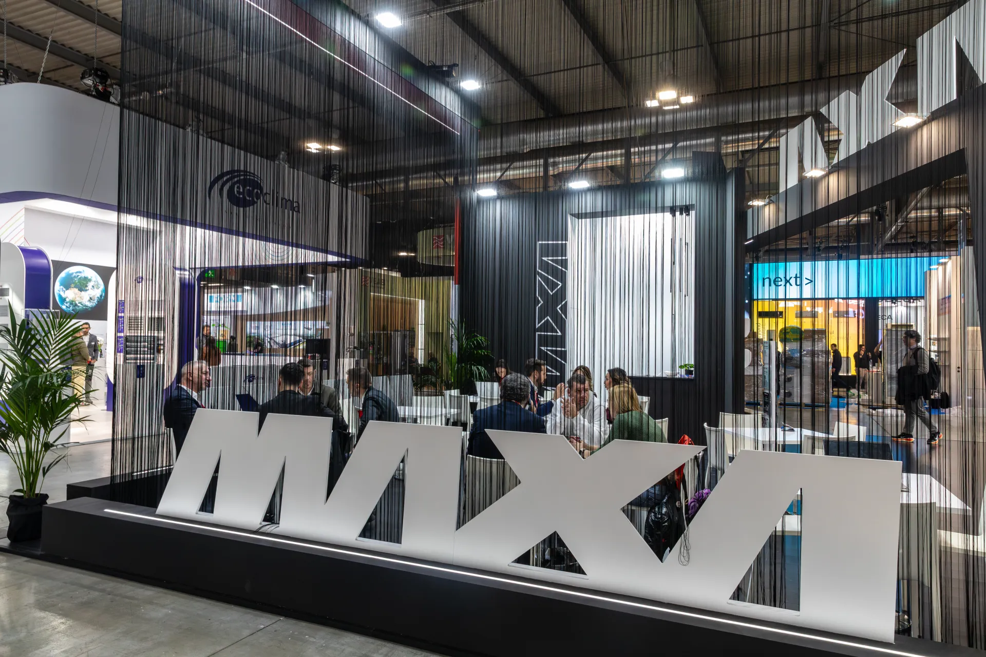 Maxa meeting area behind string curtains and freestanding logo letters at MCE 2026