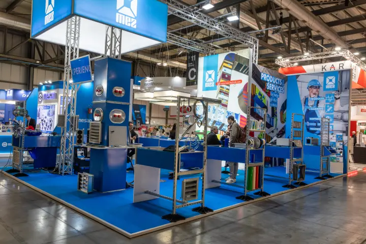 MEZ stand with blue flooring and duct component racks at MCE 2026