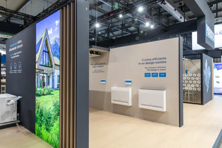 Olimpia Splendid wall-mounted units on a beige wall with Italian slogans at MCE 2026