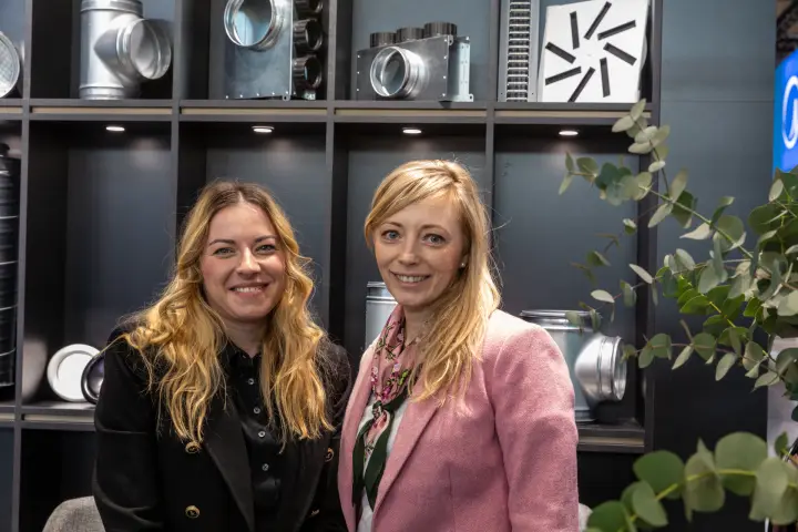 Portrait of two staff with plenum boxes and swirl diffuser behind