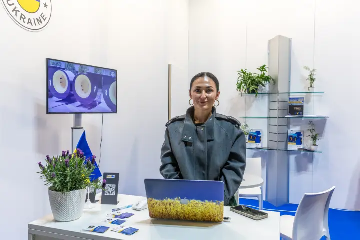 Reception desk at the KVZO stand with fan footage on screen at MCE 2026