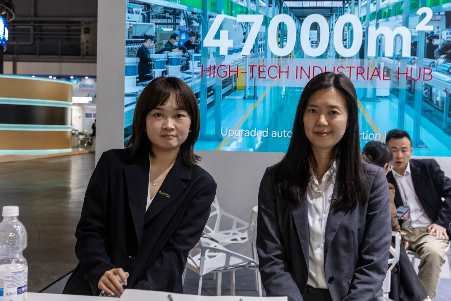 Samyou staff in front of a "47000m² High-Tech Industrial Hub" screen at MCE 2026