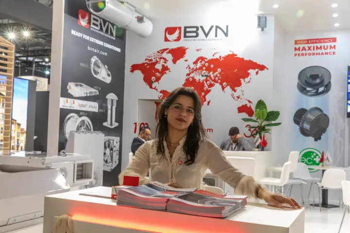 Staff member posing at the BVN counter in front of the world map at MCE 2026