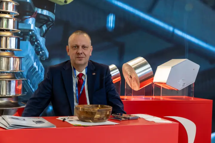 Staff member seated at a red counter with foil rolls on display
