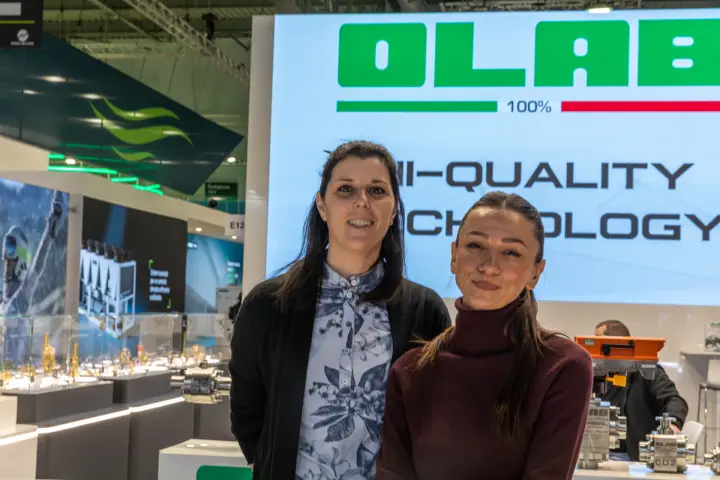 Staff at the Olab stand in front of the Hi-Quality Technology screen at MCE 2026