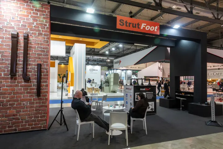 Strut Foot stand entrance with brick wall and rubber feet display at MCE 2026