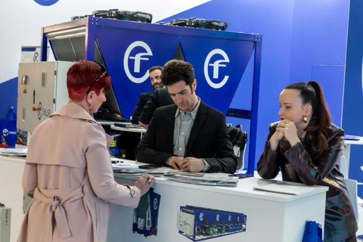 Talks at the CF Chiller counter in front of a blue chiller unit at MCE 2026