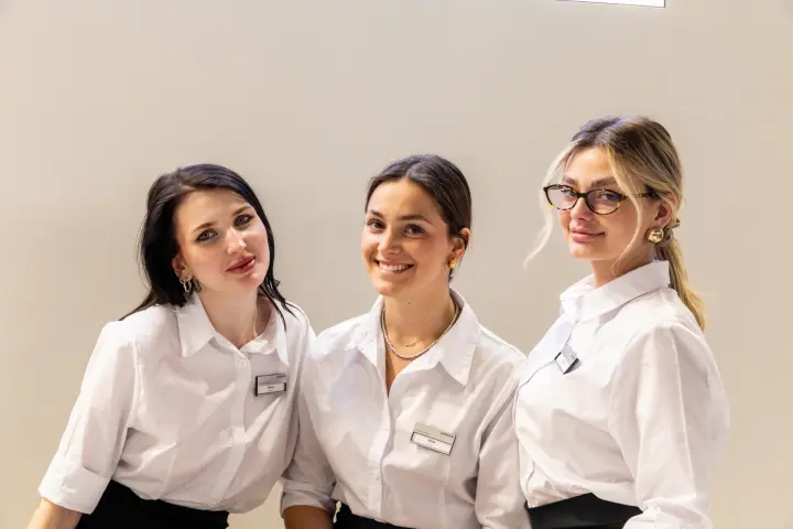 Three staff members side by side in front of a plain wall at MCE 2026