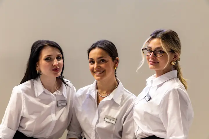 Tight portrait of three staff members in white shirts at MCE 2026