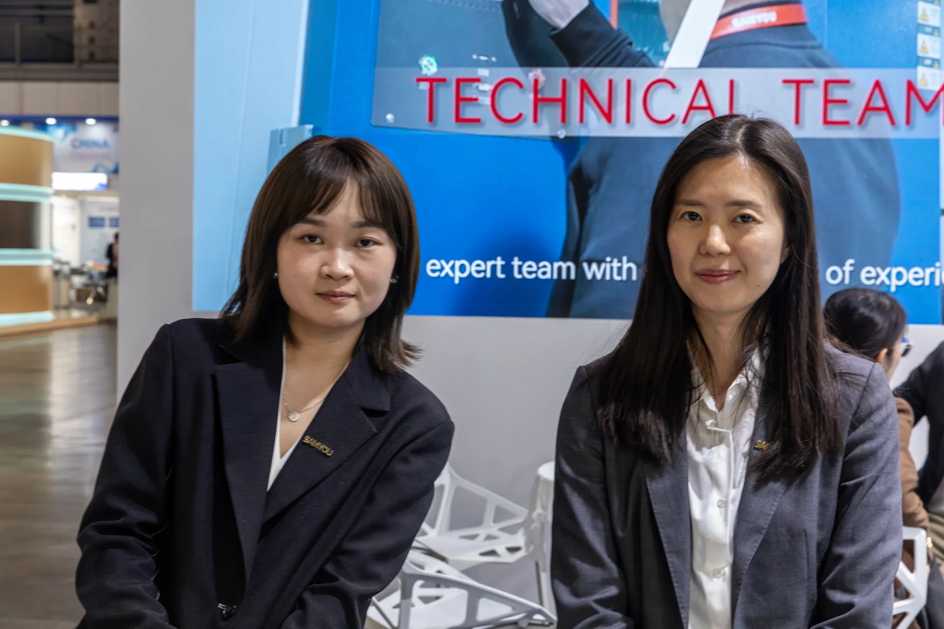 Two Samyou staff in front of a "Technical Team" screen at MCE 2026