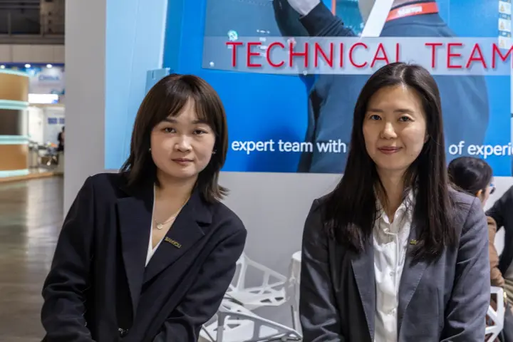 Two Samyou staff in front of a "Technical Team" screen at MCE 2026