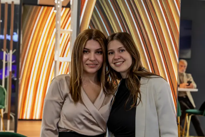 Two staff members in front of copper-striped light panels