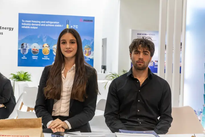 Two staff members at the Fusheng counter at MCE 2026