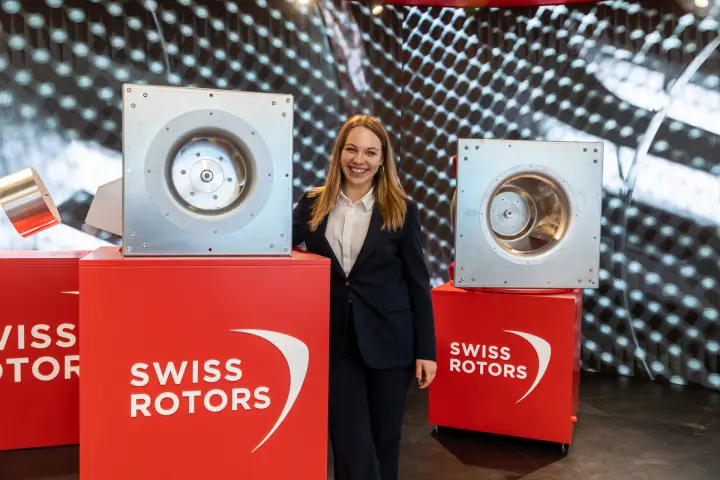 Two Swiss Rotors plug fans on red plinths before the LED wall