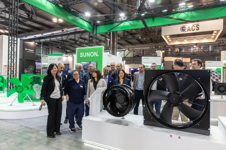 Visitor group examining black centrifugal and axial fans at Sunon at MCE 2026