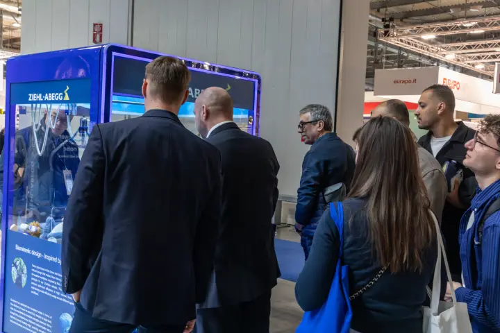 Visitors gather around a Ziehl-Abegg branded claw machine