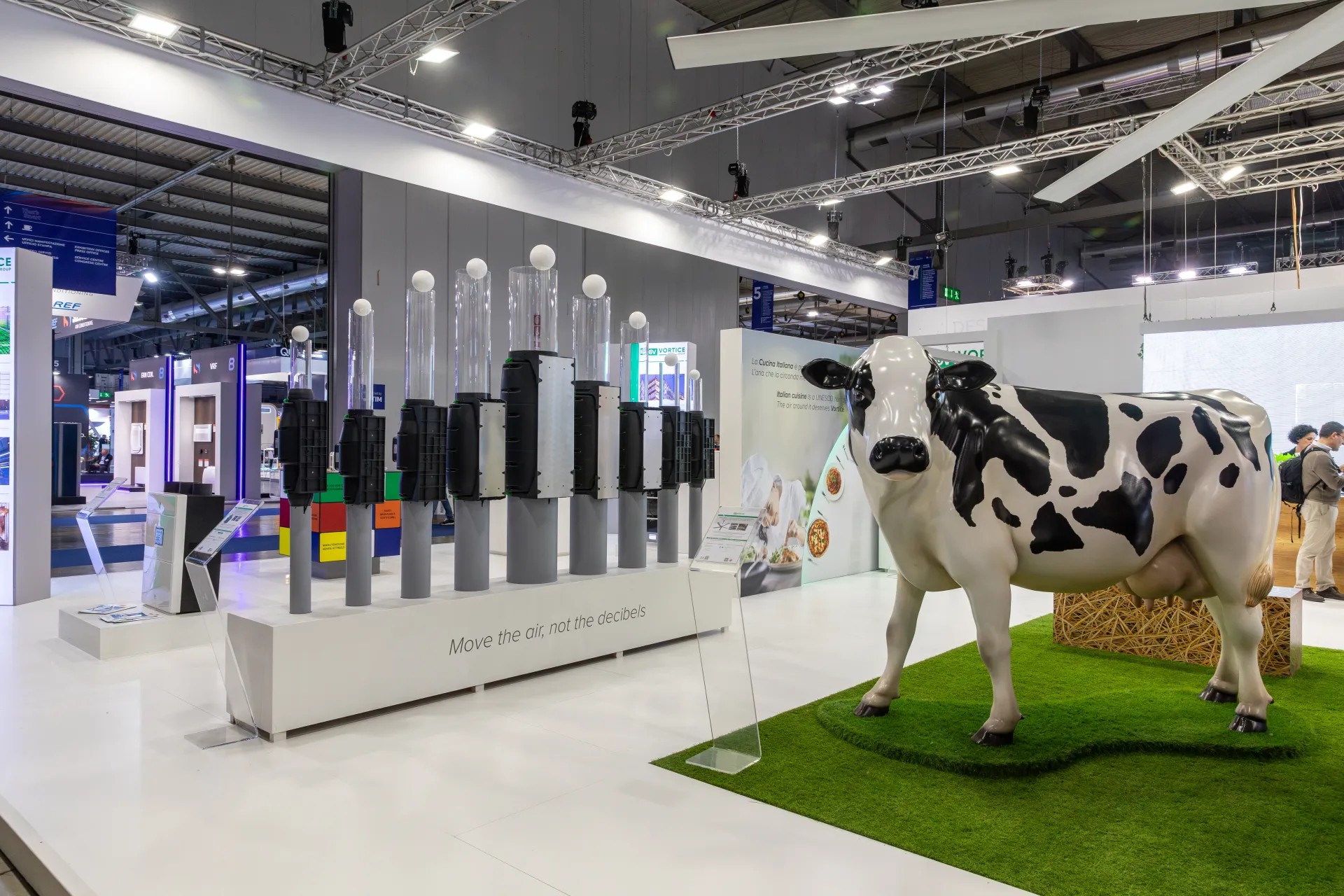 Vortice inline fan row and life-size cow sculpture on artificial grass at MCE 2026
