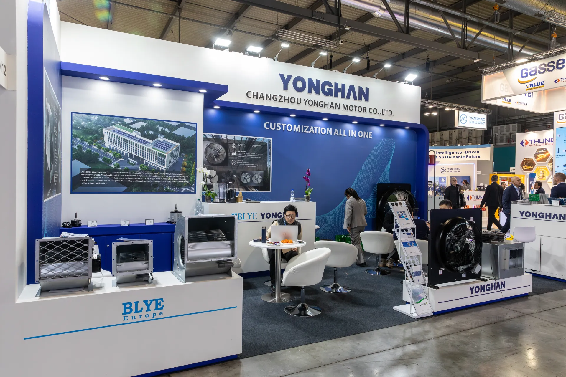 Yonghan stand with building image, Blye blowers and white lounge chairs at MCE 2026