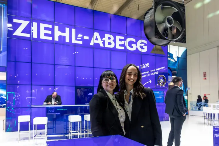 Ziehl-Abegg staff in front of logo wall and a suspended axial fan