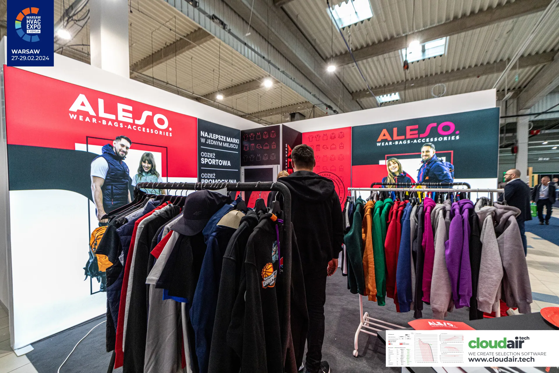 Colourful hoodies on rails under Aleso 'Najlepsze marki w jednym miejscu' panels at Warsaw HVAC Expo 2024