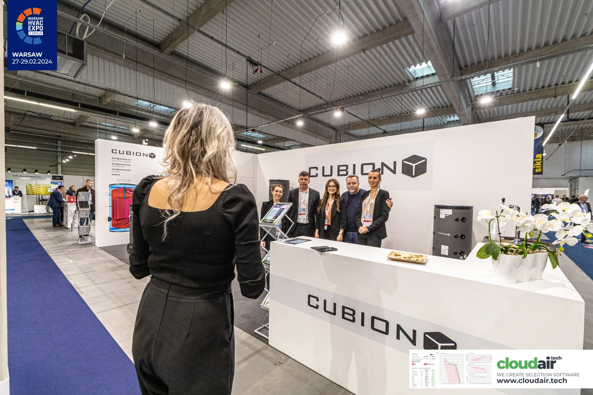 Cubion stand seen from the aisle during a team photo at the counter at Warsaw HVAC Expo 2024