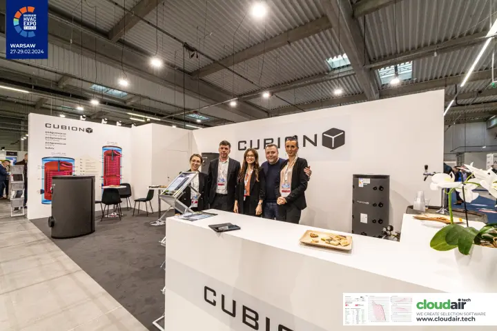 Cubion team at the white reception counter with hot water cylinders at Warsaw HVAC Expo 2024