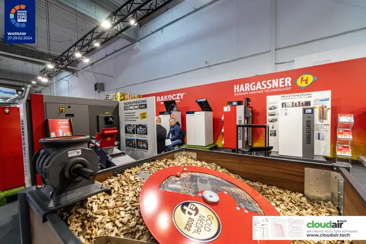 Hargassner wood chip agitator with a Gold Medal 2022 plaque in a chip-filled bin at Warsaw HVAC Expo 2024