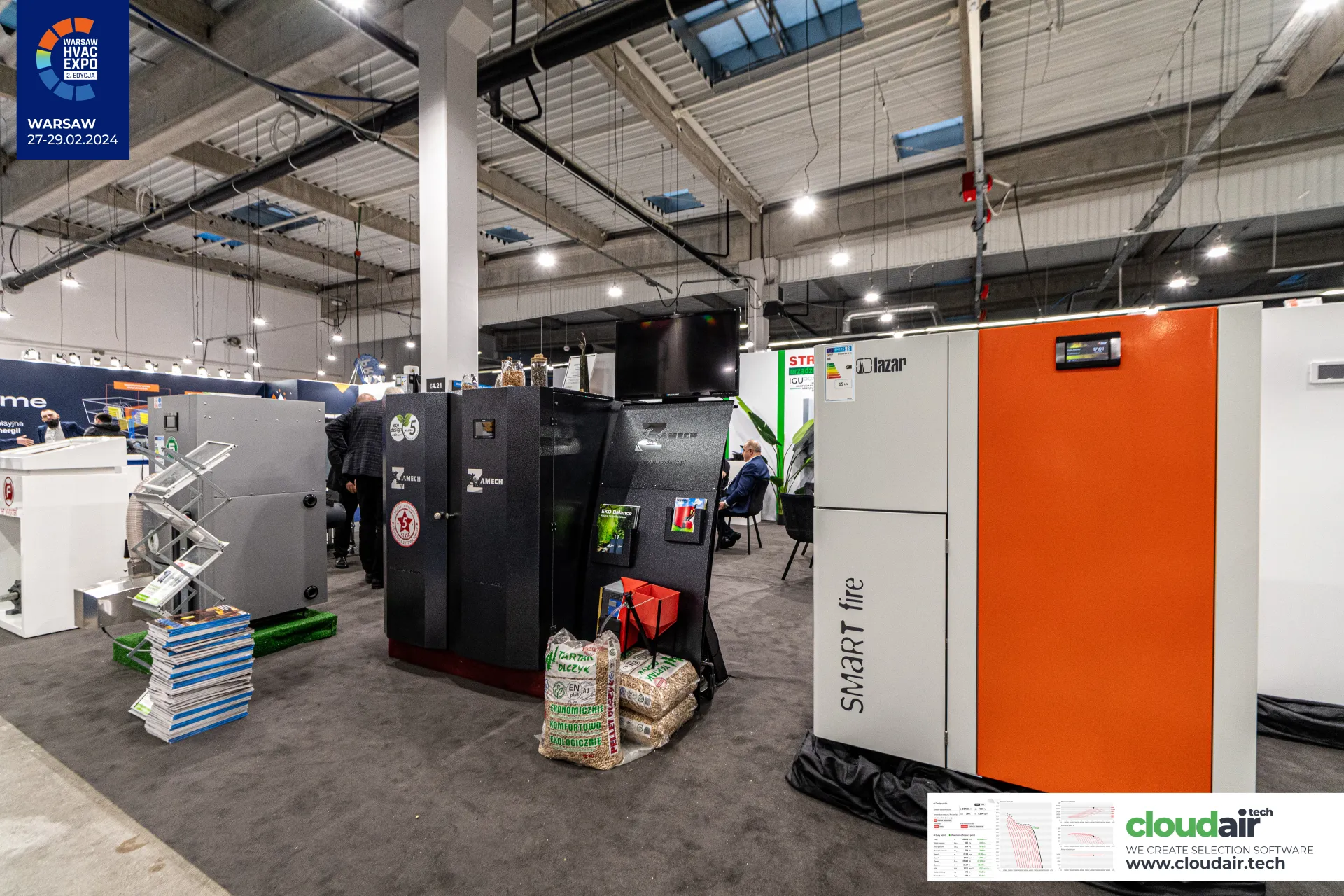 Lazar SMART fire boiler beside Zamech boilers and bags of wood pellets at Warsaw HVAC Expo 2024