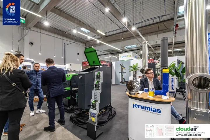MCE boiler with open fuel hopper beside Jeremias chimney systems at Warsaw HVAC Expo 2024