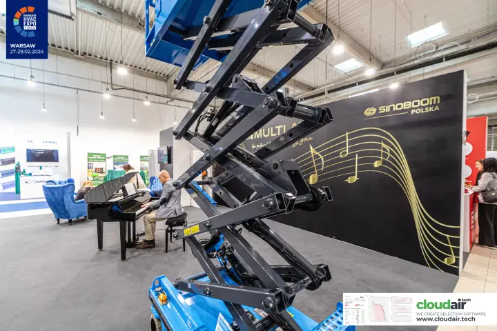 Scissor arms of a raised Sinoboom lift against the Sinoboom Polska wall at Warsaw HVAC Expo 2024