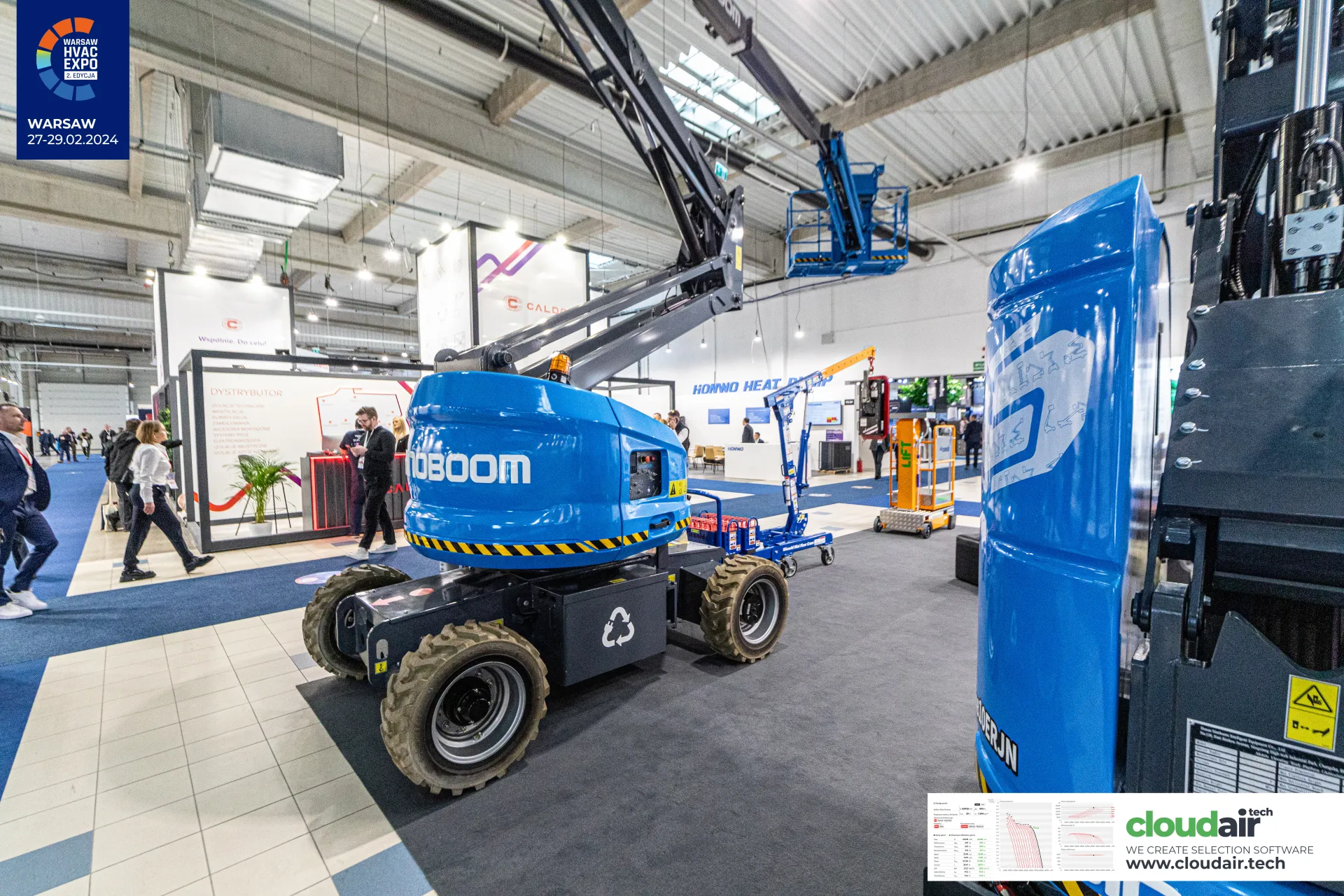 Sinoboom articulated boom lift with raised basket beside a mast lift counterweight at Warsaw HVAC Expo 2024