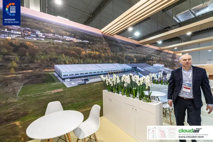 Stand lounge with orchid planters below a factory panorama wall
