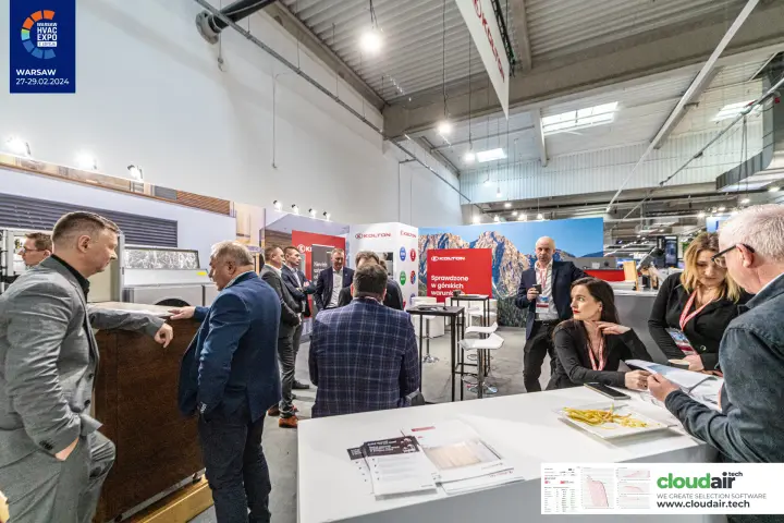 Visitors in discussion at the Kolton stand under a hanging sign at Warsaw HVAC Expo 2024