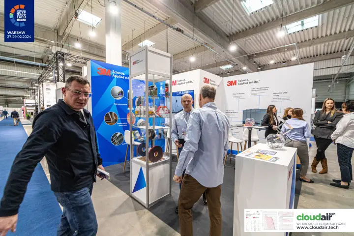 Visitors passing the 3M stand with its glass tape display tower