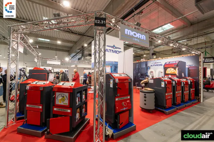 Atmos solid-fuel boilers under a Mora 1995 sign on a truss stand at Warsaw HVAC Expo 2026