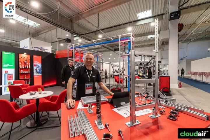 Fischer strut-channel frame and pipe clamp samples on the red demo table at Warsaw HVAC Expo 2026