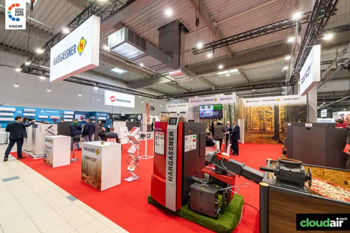 Hargassner wood chip boiler and feed auger on a red-carpeted stand at Warsaw HVAC Expo 2026