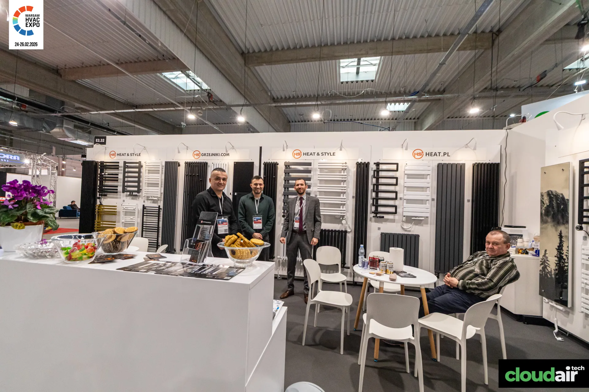 Heat & Style reception counter in front of a wall of designer radiators at Warsaw HVAC Expo 2026