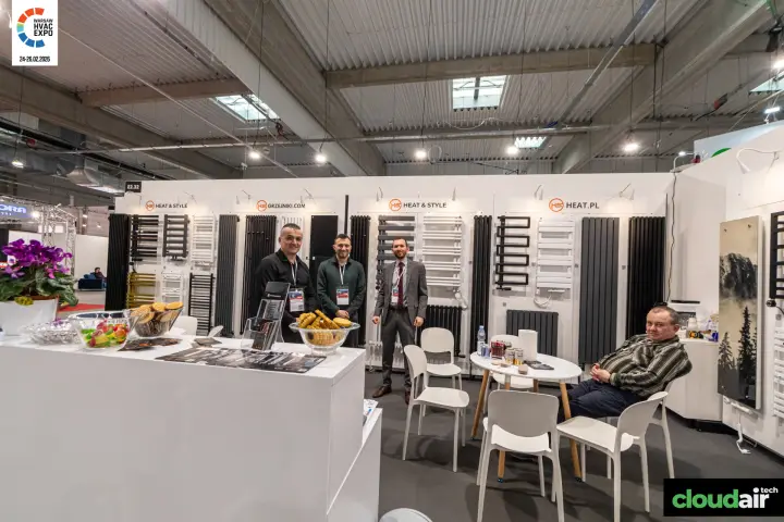 Heat & Style reception counter in front of a wall of designer radiators at Warsaw HVAC Expo 2026
