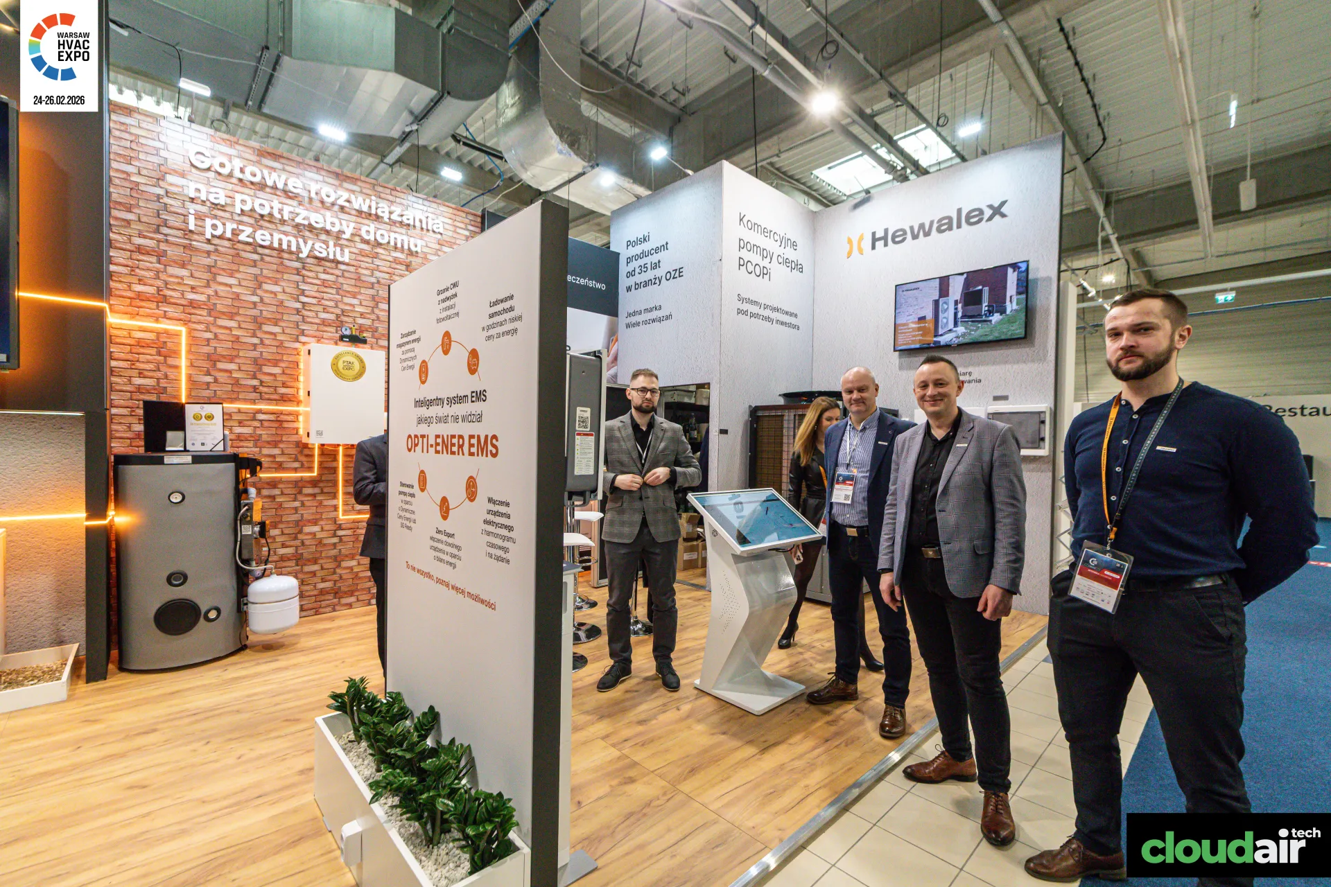 Hewalex team beside the OPTI-ENER EMS board and touchscreen kiosk at Warsaw HVAC Expo 2026