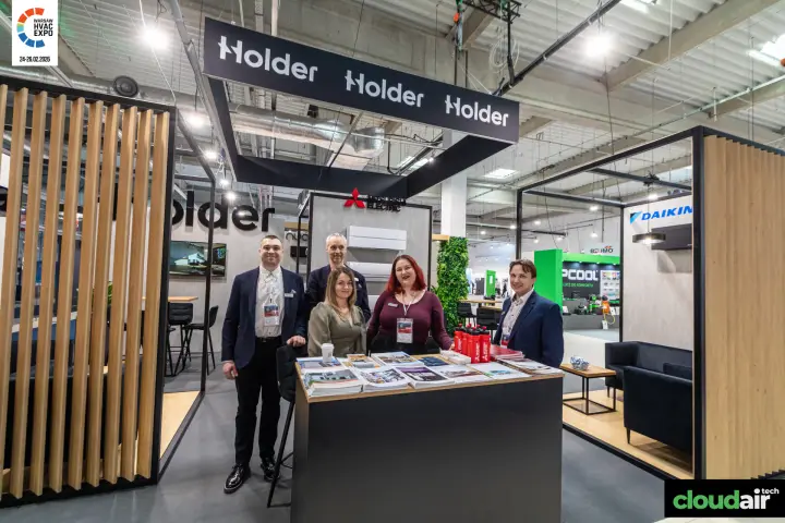 Holder team at the reception counter under the suspended logo frame