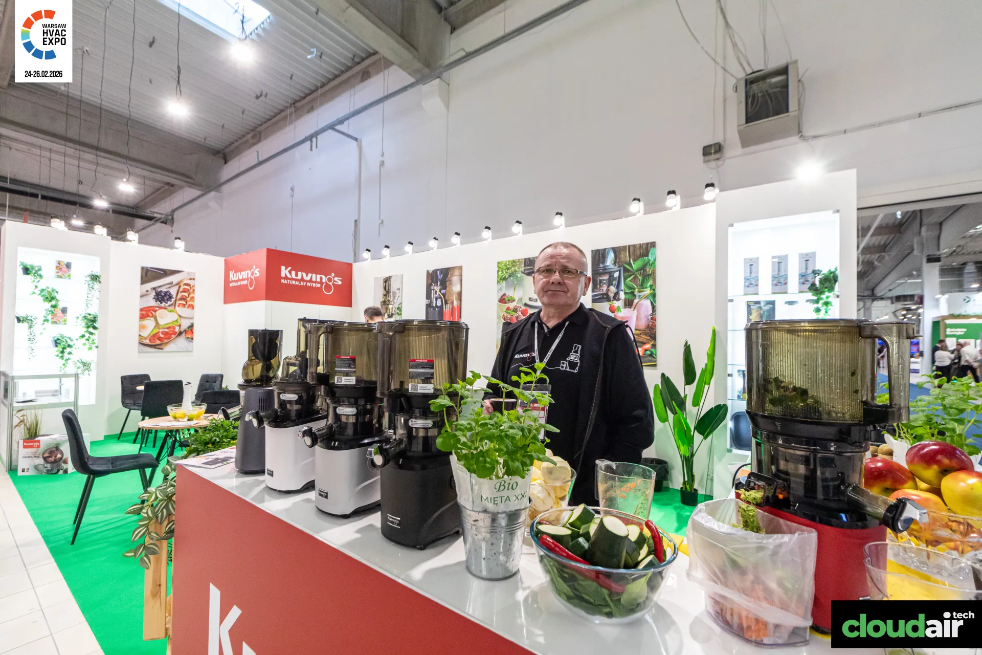 Kuvings juicers lined up on the counter with produce and potted mint at Warsaw HVAC Expo 2026