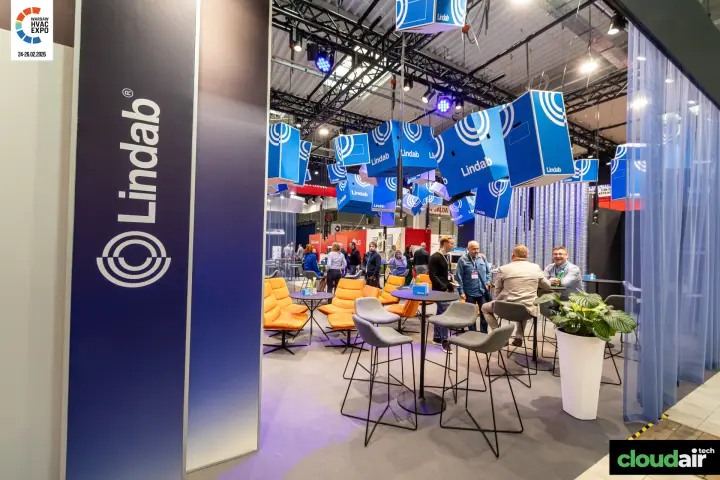 Lindab lounge with orange chairs under hanging logo cubes