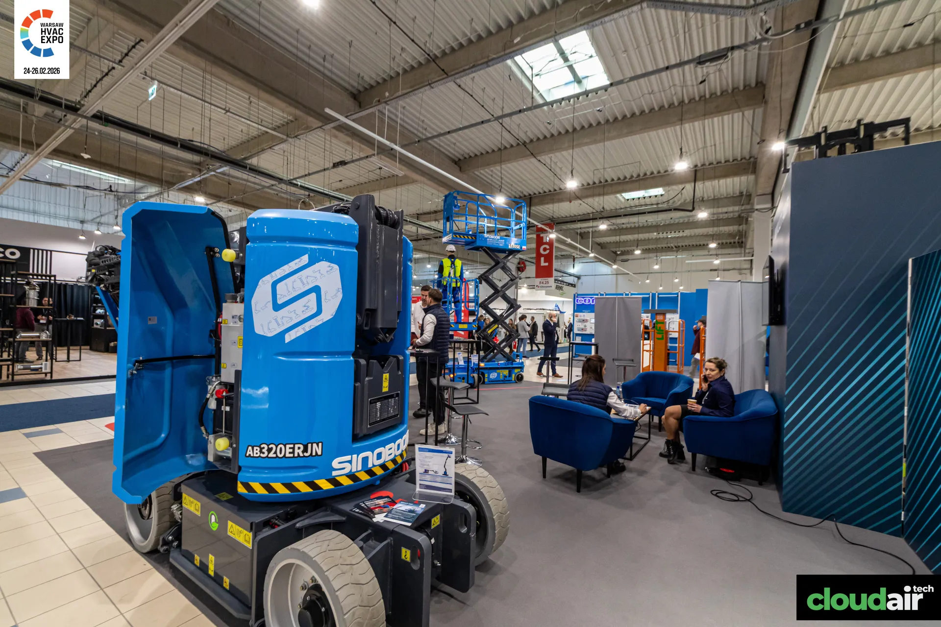 Sinoboom AB320ERJN boom lift with open cover and a raised scissor lift at Warsaw HVAC Expo 2026
