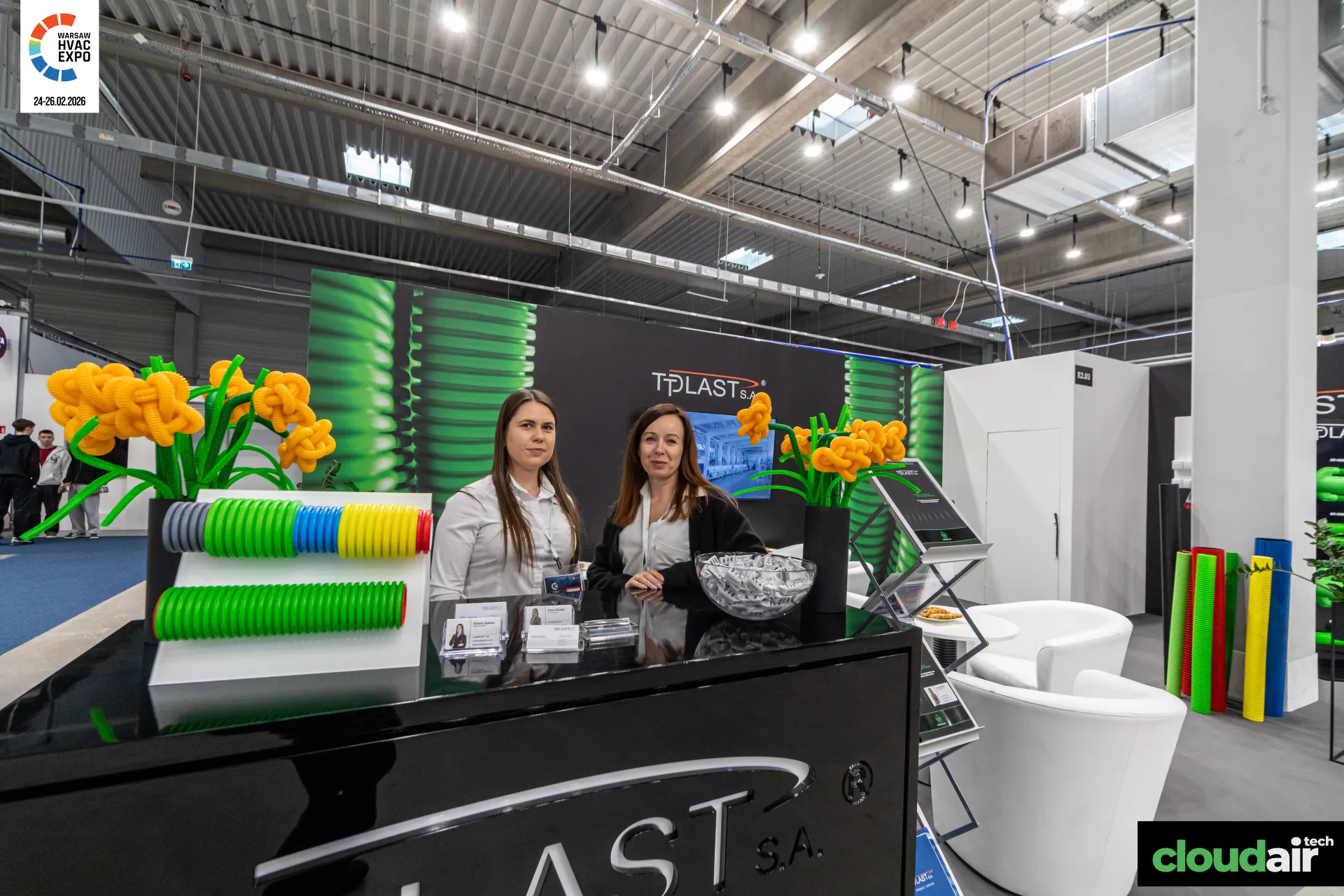 Tplast counter with coloured corrugated pipe samples and flower decor at Warsaw HVAC Expo 2026
