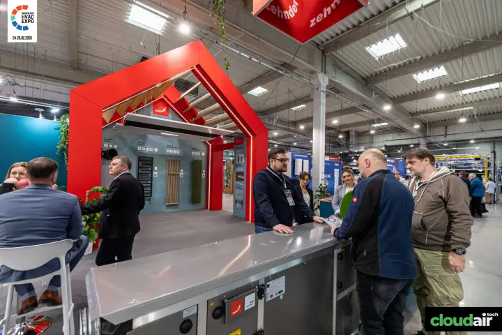 Visitors talking over a Zehnder air handling unit by the radiator portal